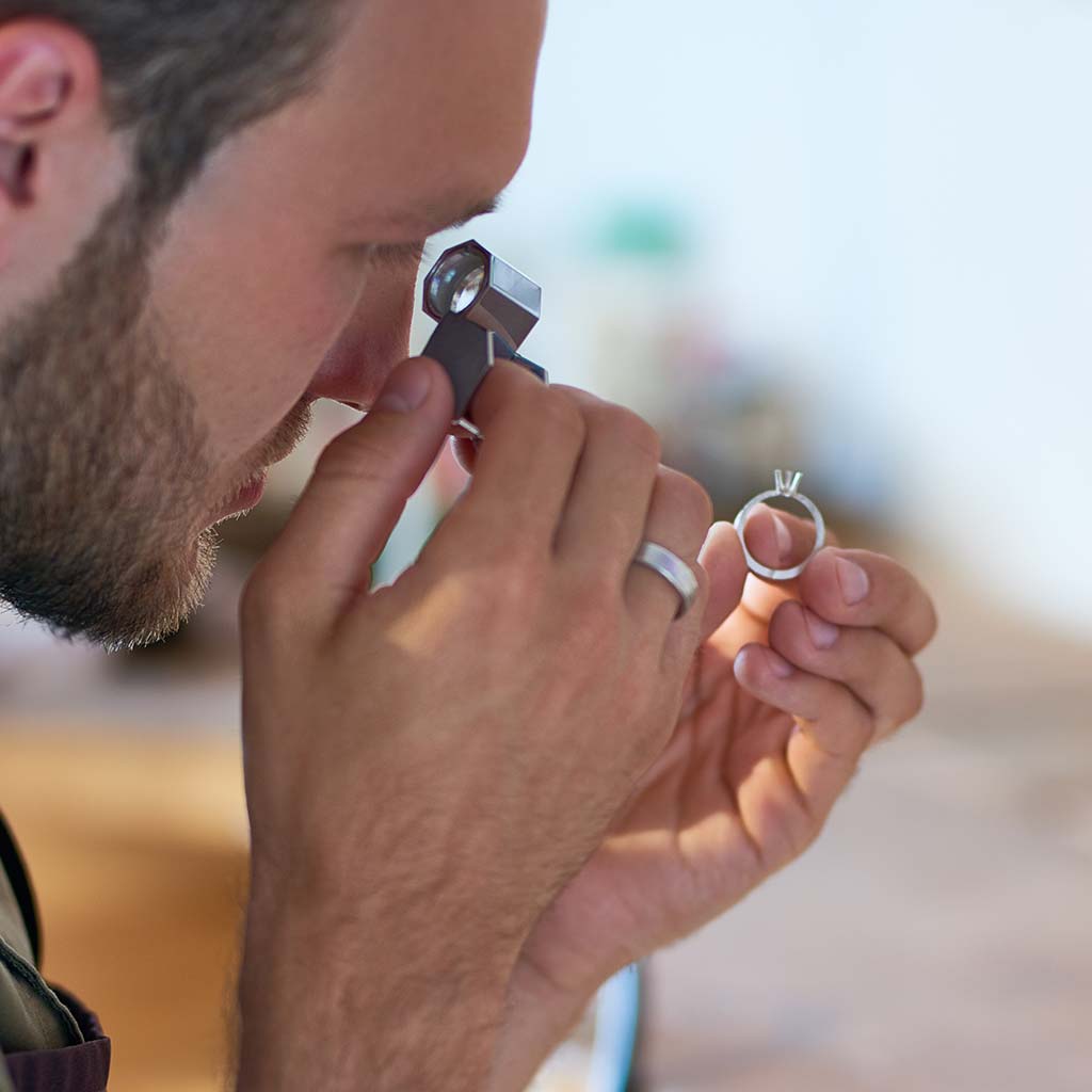 Jeweler appraising engagement ring in Jacksonville jewelry store